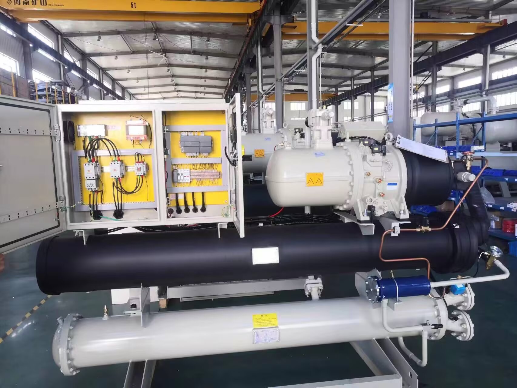 Industrial water screw chiller with open electrical control panel for inspection